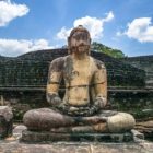 Eine alte, sitzende Buddha-Statue im Felsentempel in der Ausgrabungsstätte des historischen Parks Polonnaruwa.
