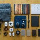 Laptops, Festplatten, Handys und mehr technische Ausrüstung angeordnet auf einem Holzfußboden.