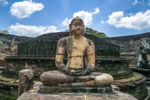 Eine alte, sitzende Buddha-Statue im Felsentempel in der Ausgrabungsstätte des historischen Parks Polonnaruwa.