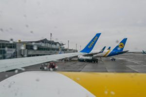 Blick aus Flugzeugfenster auf Flugzeuge und Rollfeld.