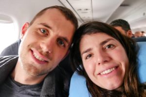 Steffen und Farina glücklich lächelnd im Flugzeug.