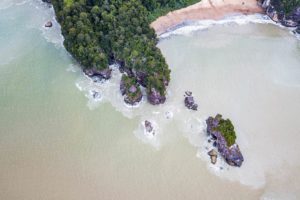 Ein Drohnenfoto zeigt einen Strand und die Felsen an der Küste des Bako Nationalparks.