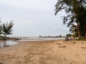 Einige Menschen befinden sich auf dem fast leeren Strand Pantai Tanjung Lobang in Miri.