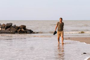 Steffen läuft durch das seichte Wasser am Strand von Miri.