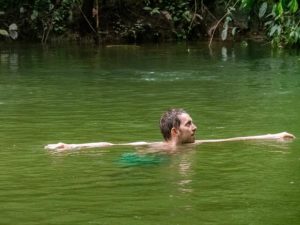 Steffen schwimmt im Regenwald im Fluss
