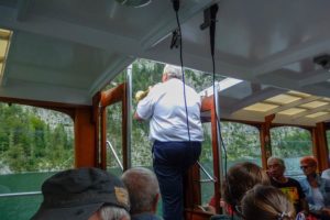 Der Bootsmann spielt auf seinem Flügelhorn auf dem Königssee.