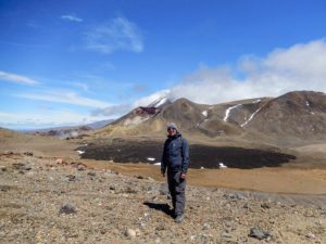 Steffen steht vor dem dem Central Crater und einem schwarzen Lavafeld.