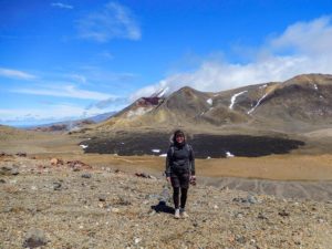 Farina steht vor einem schwarzen Lavafeld auf dem Tongariro Alpine Crossing.