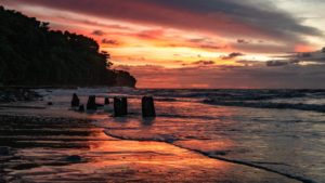 Am Strand von Miri spiegelt sich der Sonnenuntergang im Wasser.