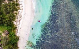 Ein Fischerbood liegt friedlich am weißen Sandstrand.