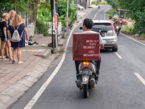 Ein Rollerfahrer liefert Essen des Betlenut Cafés aus.
