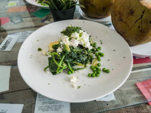 Ein Frühstücksteller mit Erbsen, Spinat und pochiertem Ei.